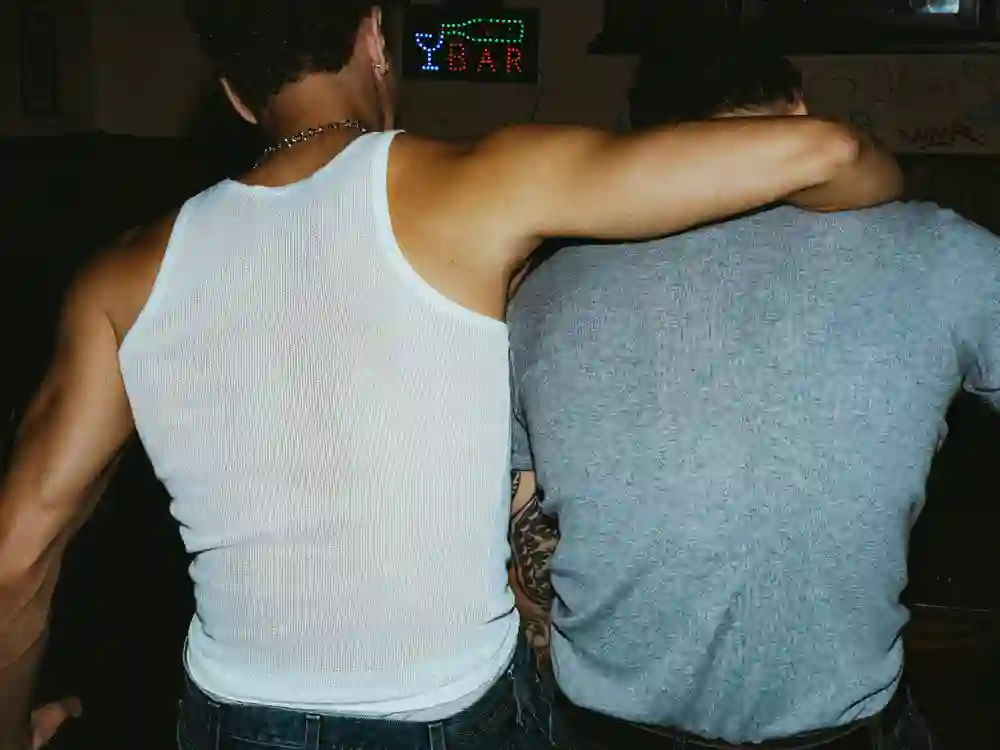 Zwei Personen Arm in Arm, von hinten fotografiert